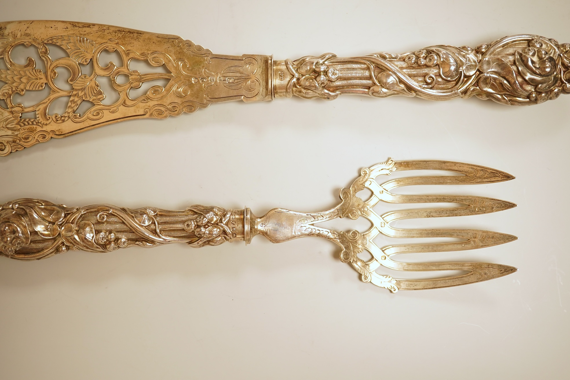 A pair of Victorian ornate silver fish servers, by John Gilbert, Birmingham, 1864, 34.1cm.